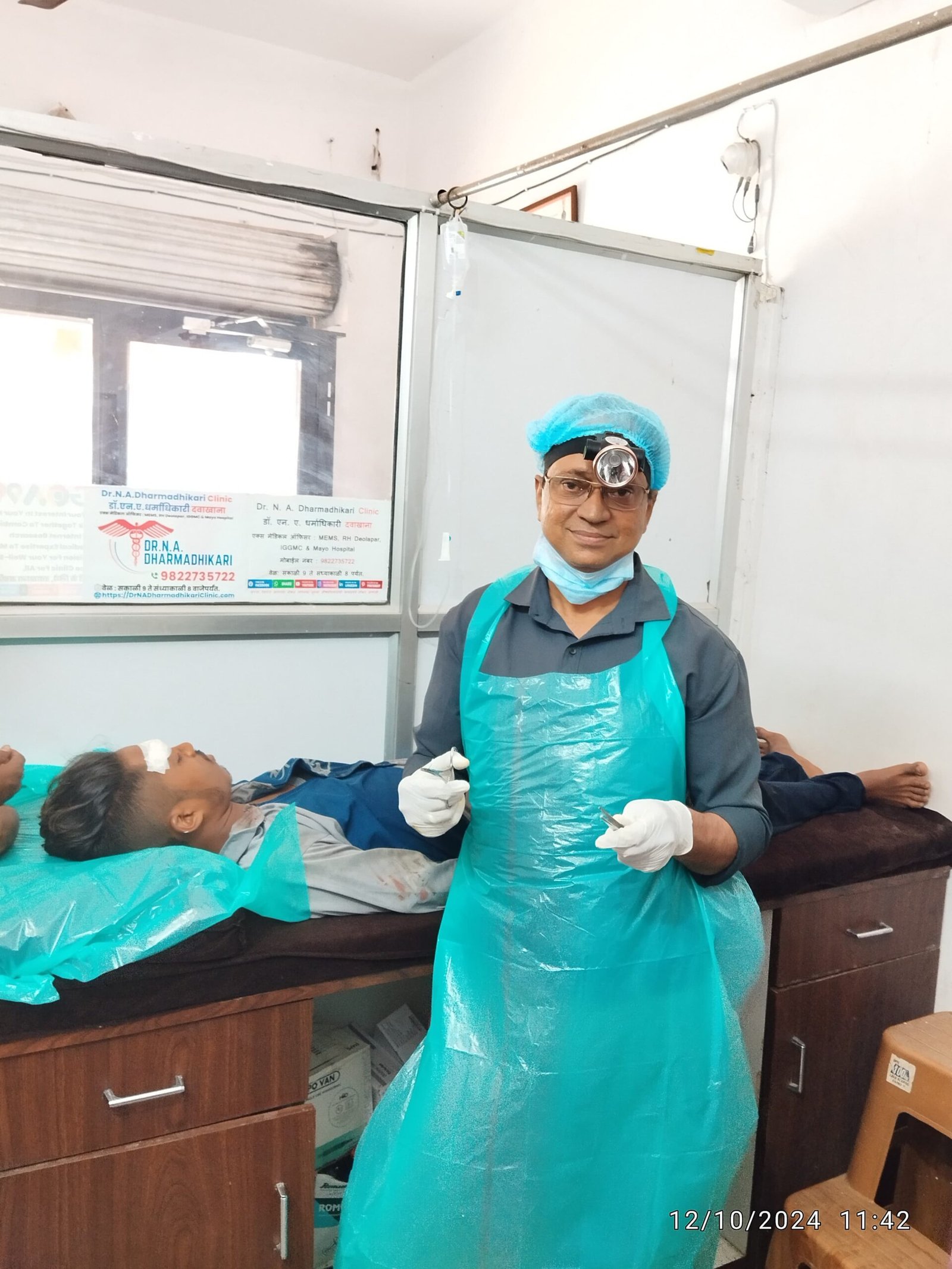 Dr. N. A. Dharmadhikari performing tissue suturing for a road traffic accident patient at his clinic