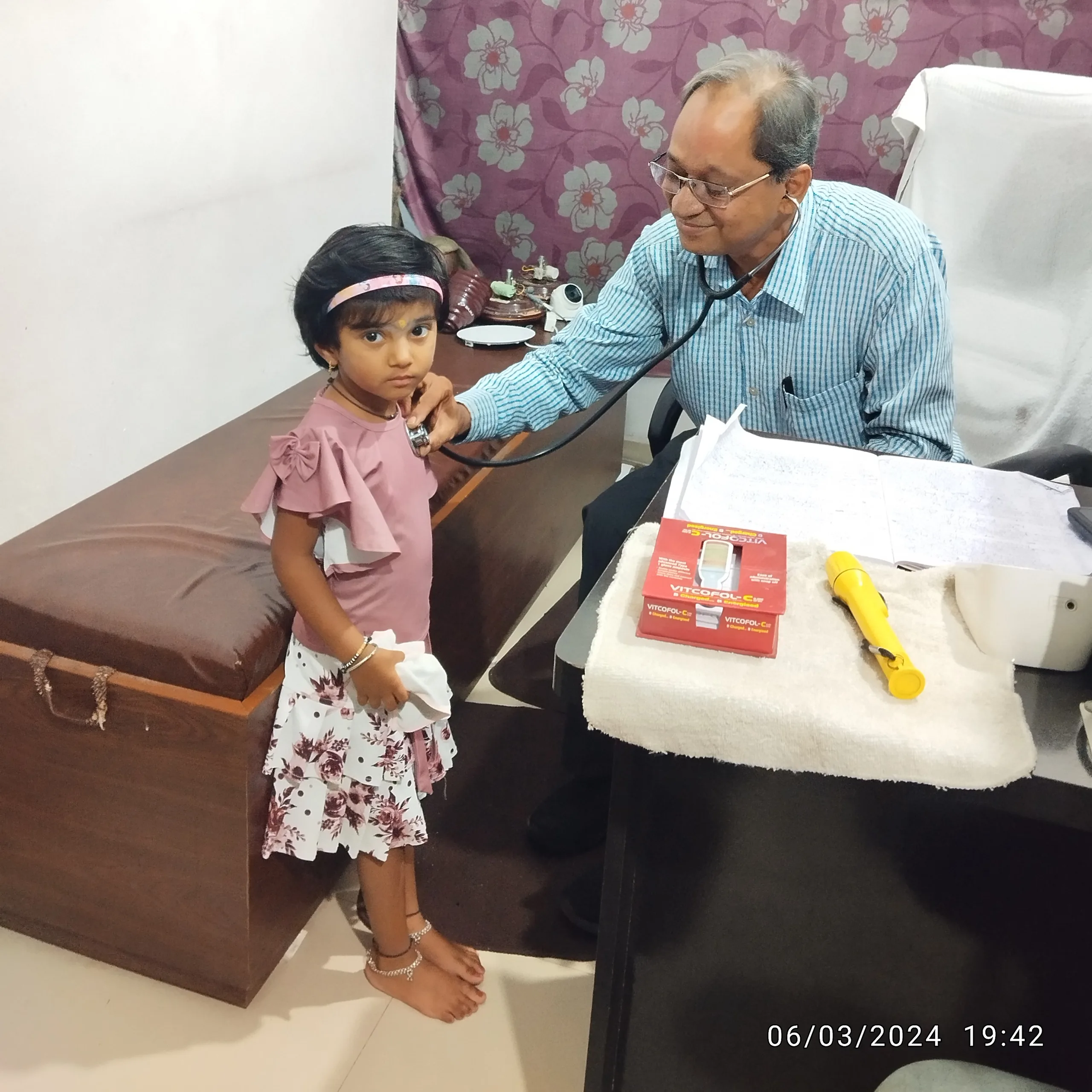 Young girl calmly undergoing chest examination.