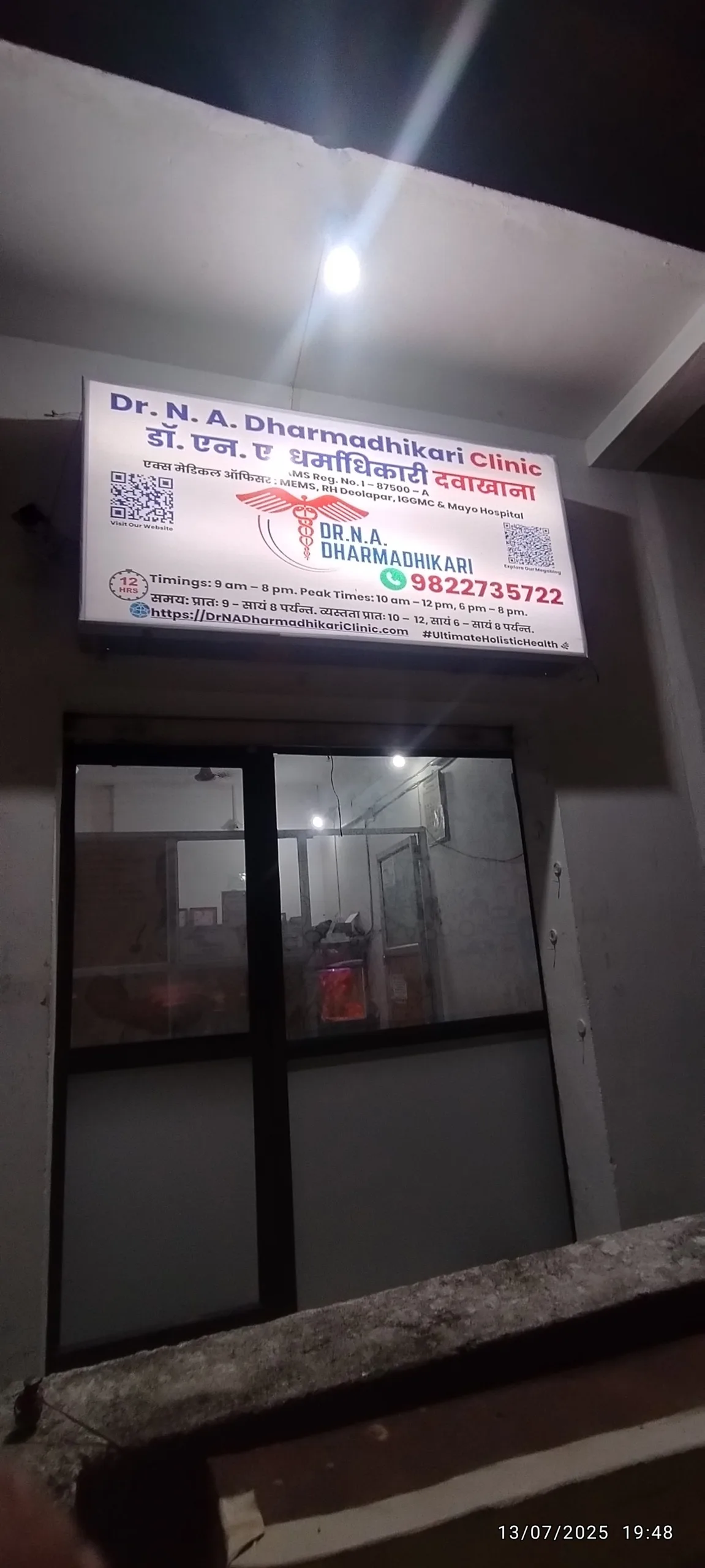 Night view of Dr. N. A. Dharmadhikari Clinic with illuminated entrance.