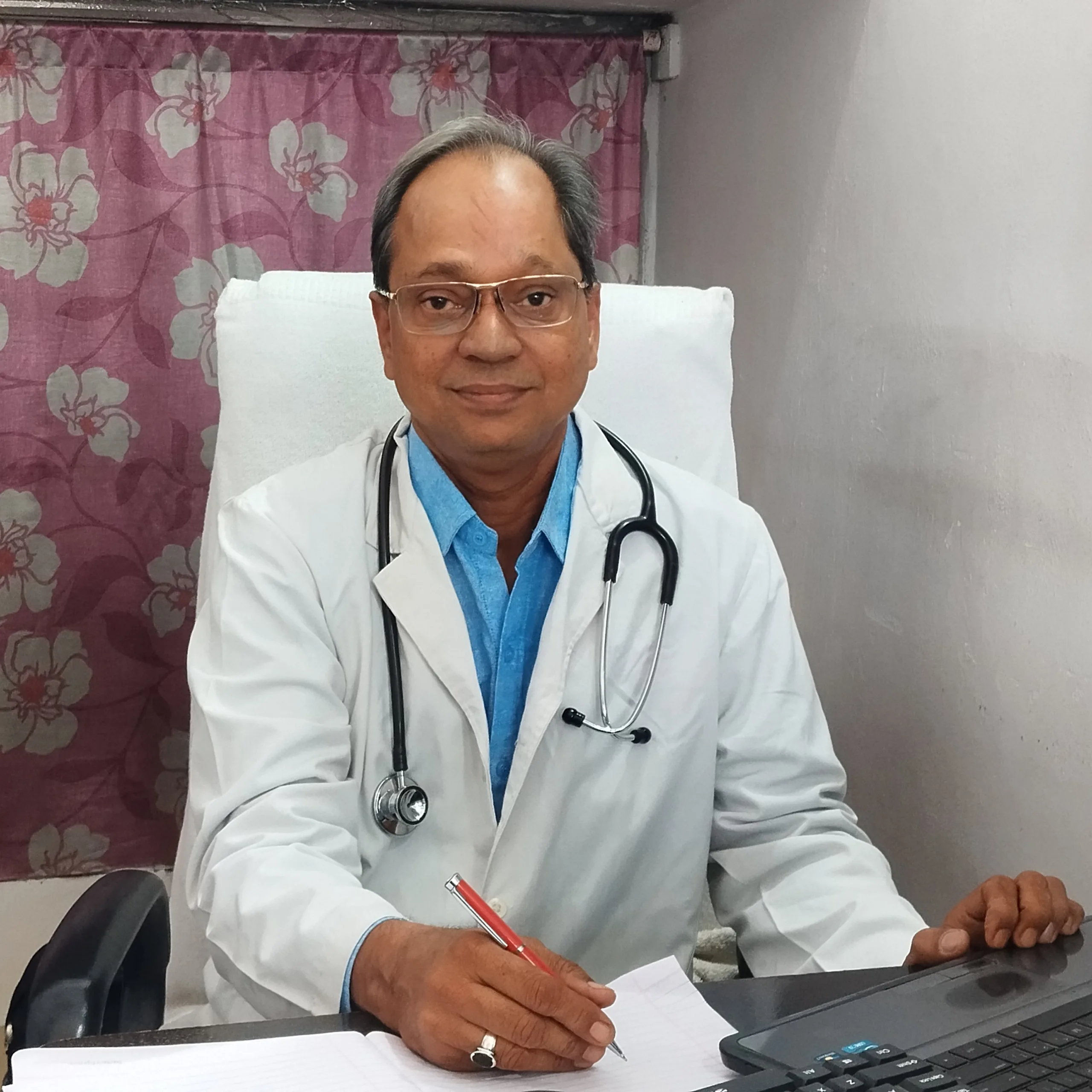 Dr. N. A. Dharmadhikari seated in the outpatient consultation room providing personalized healthcare.
