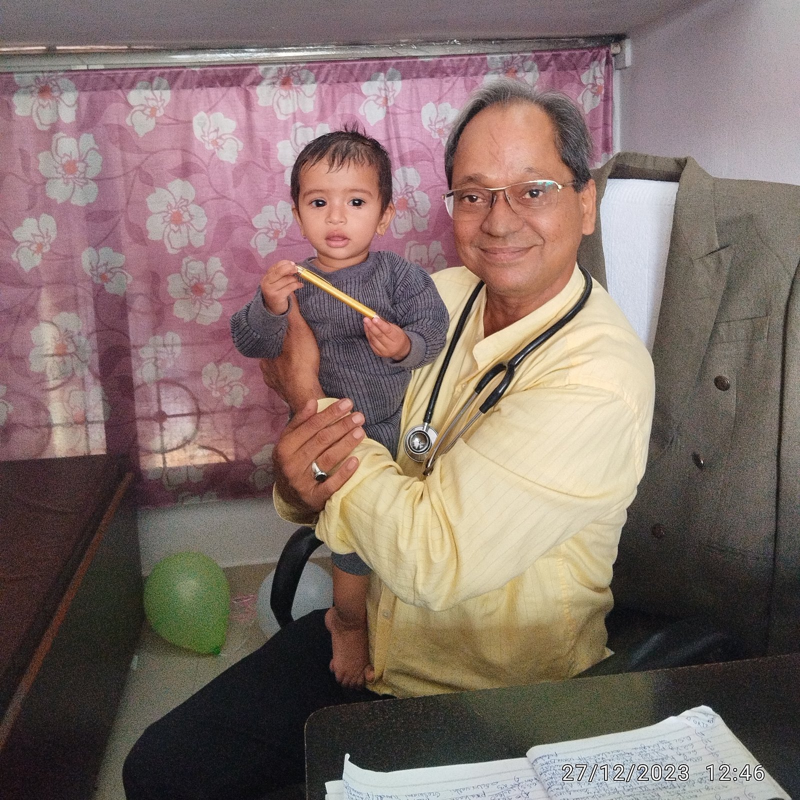 Toddler girl comfortably interacting with Dr. N. A. Dharmadhikari during consultation.