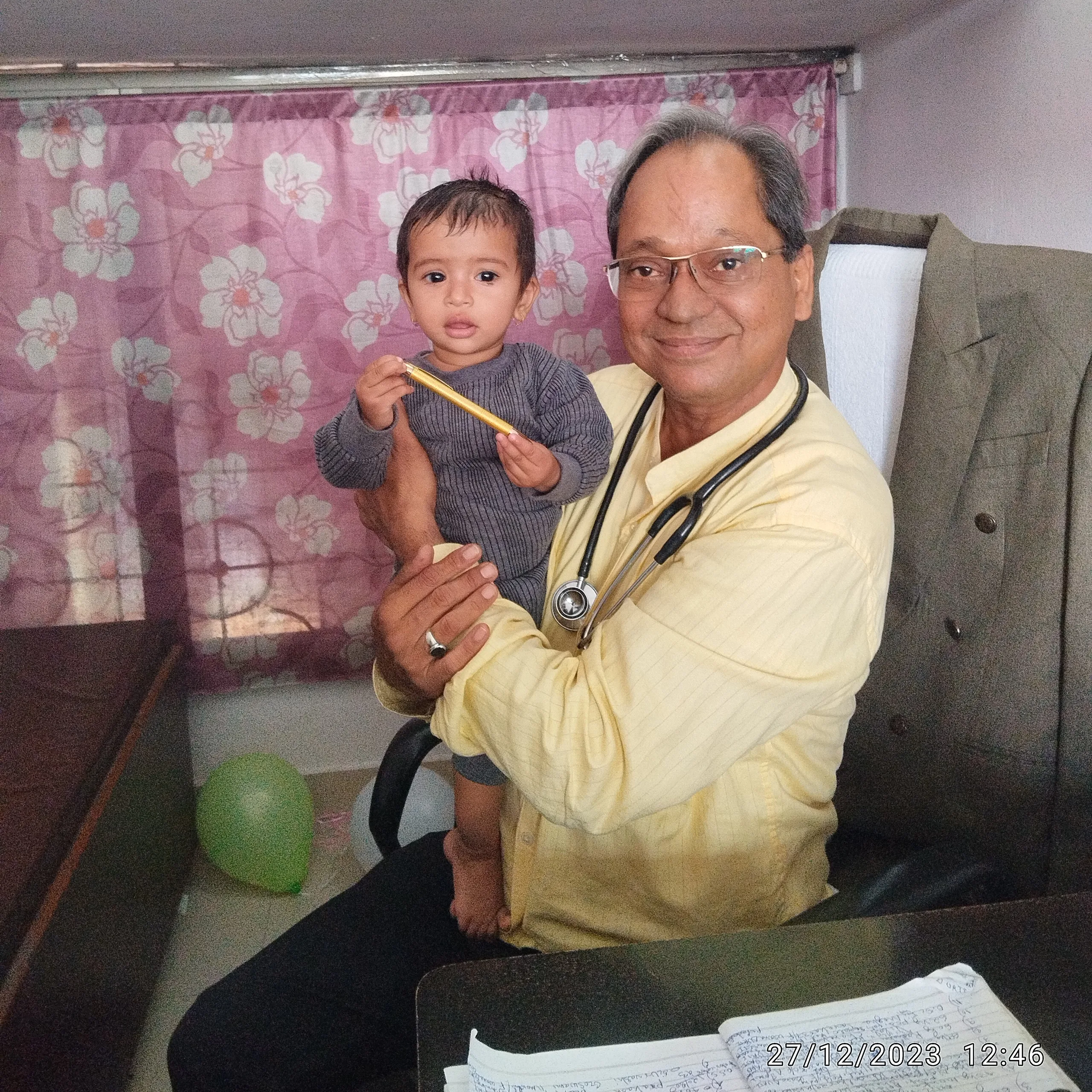 Toddler girl comfortably interacting with Dr. N. A. Dharmadhikari during consultation.